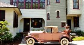 A vintage car in front of the Stetson Mansion
