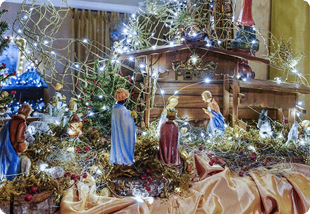 A lit nativity scene among the Christmas decorations