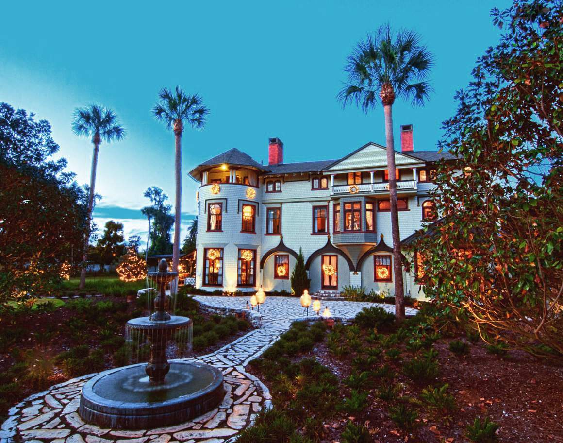The Stetson Mansion lit at dusk behind the courtyard fountain