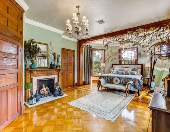 A designer decorated bedroom with its original fireplace and parquet floor