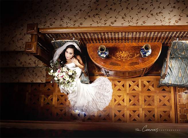 A bride seated on an antique settee inside the Mansion