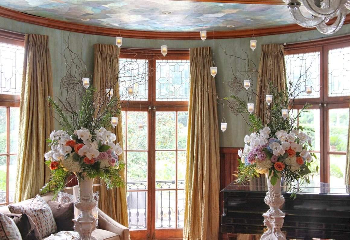 Tall floral arrangements in the bay window of the parlor