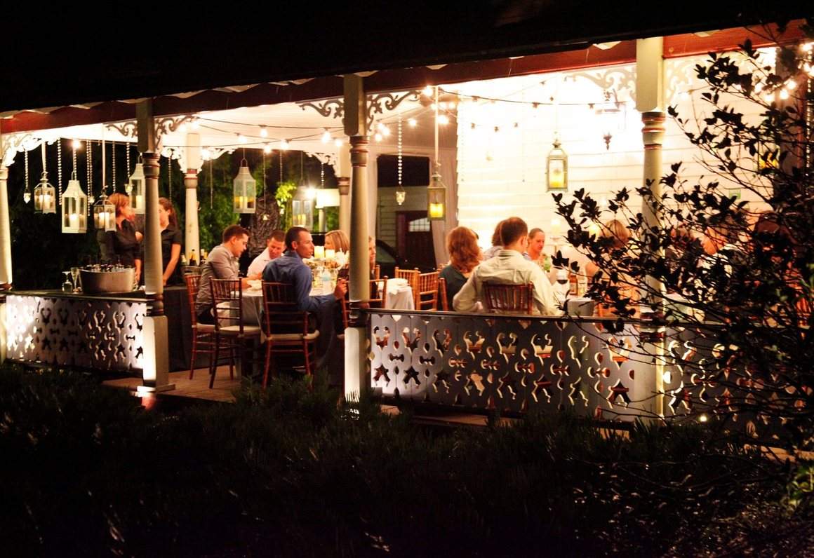 Guests at dinner on the porch after dark