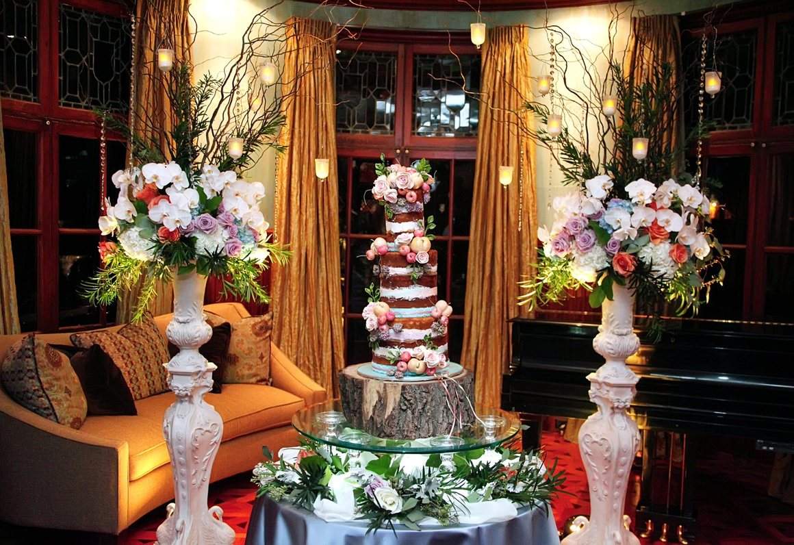 The wedding cake beside the florals in the parlor
